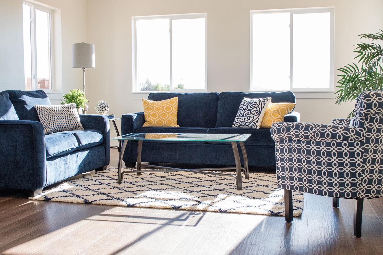 living room with lots of natural light, blue couches and soft chair