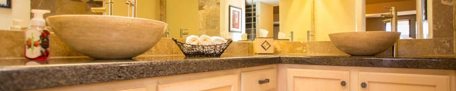 master bathroom with two stone bowl shaped sinks on granite countertops